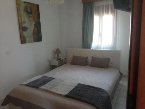 um quarto com uma cama e uma janela em Snuggery Elegant Apartment em Agios Nikolaos