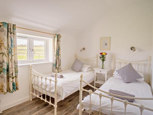 2 camas individuales en una habitación con ventana en 4 Bed in Newport 90251, en Newport