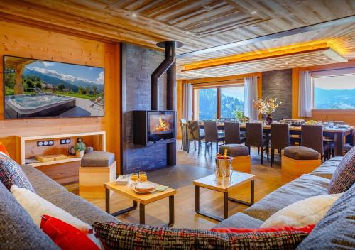 a living room with a fireplace and a dining room at Chalet Chamallow - Les Congères in Manigod