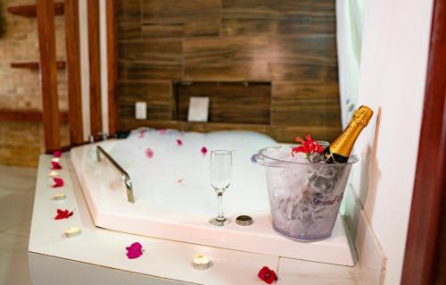 uma banheira com uma garrafa de champanhe e um copo em Hotel Marinas em Pipa