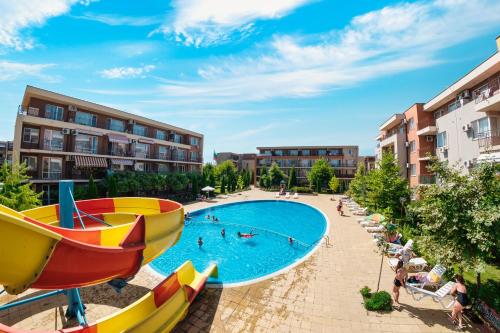 a large swimming pool with people in a resort at Holiday and Orchid Fort Noks Apartments in Sunny Beach