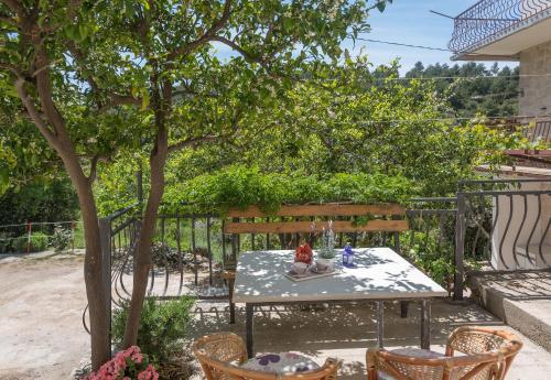 a table and chairs under a tree on a patio at Kuća za odmor LAVANDA in Drvenik