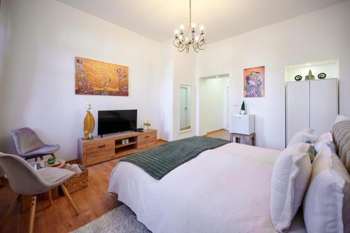 a bedroom with a large white bed and a television at Čudesni drvored in Kikinda