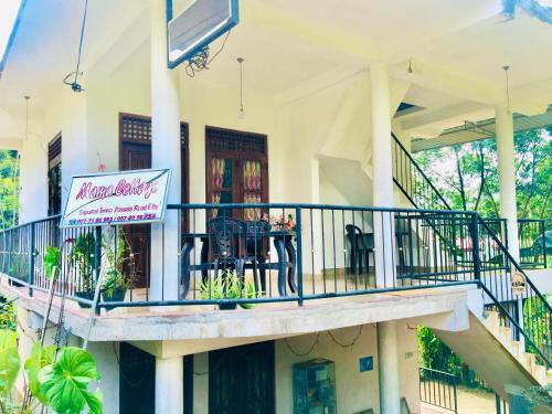 a building with a balcony with a sign on it at Mama Cottage Ella in Ella