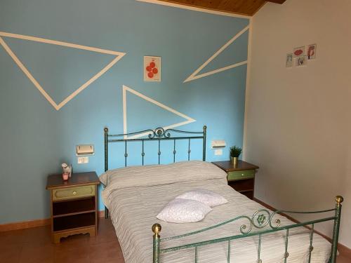 Schlafzimmer mit einem Bett mit blauer Wand in der Unterkunft Fattoria Paradiso in Bertinoro