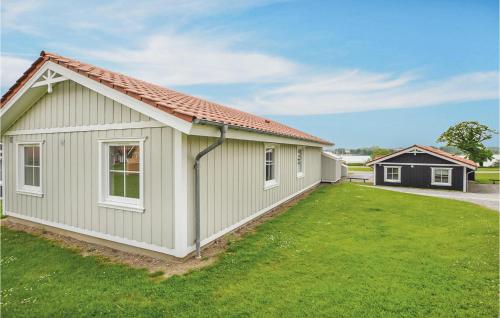 a small house with a green yard at Marina Fiskenæs Feriepark in Gråsten