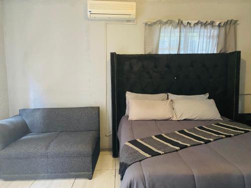 a bed and a chair in a room at Ashridge Guesthouse & Safaris in Hazyview