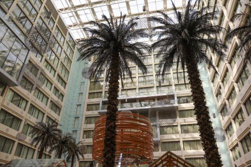 twee palmbomen voor een gebouw bij Crowne Plaza Kuwait Al Thuraya City, an IHG Hotel in Koeweit