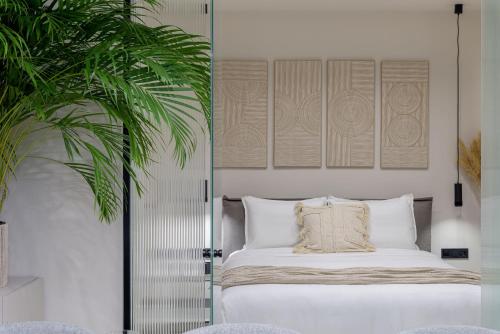 ein Schlafzimmer mit einem Bett und einer Topfpflanze in der Unterkunft Penthouse W/ View & Plunge Pool in Athen