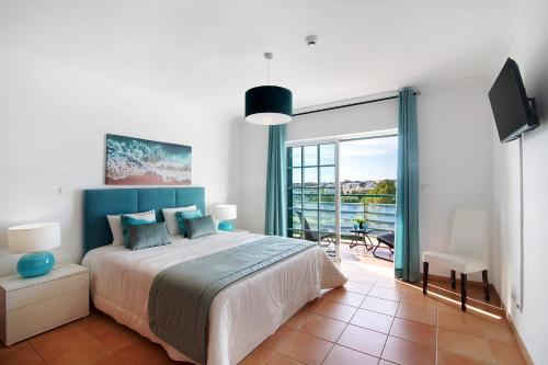 sypialnia z dużym łóżkiem i balkonem w obiekcie Apartamento Mar a Vista w mieście Portimão