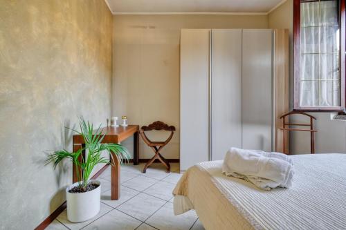 a bedroom with a bed and a table and a plant at Extra Comfort - Casa Vicino a Milano e Linate in Zelo Buon Persico