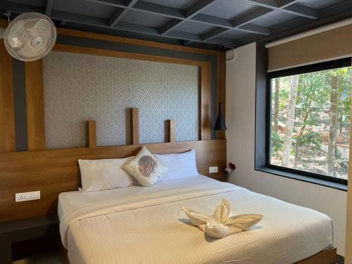 ein Schlafzimmer mit einem Bett mit einer Blume darauf in der Unterkunft Wildrootstay 3 bed cottage in Pinangode