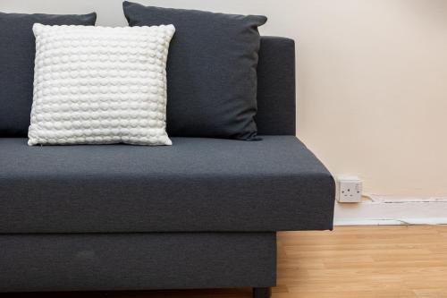 a blue couch with a pillow on top of it at Peaceful 1BR in Vibrant South Bank, 7min Borough in London