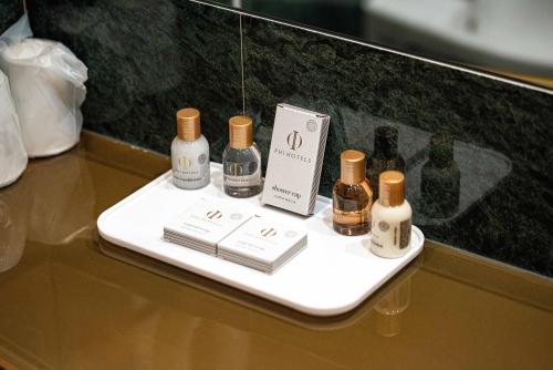 a shelf with bottles of perfume and books on a table at Phi Hotel Emilia in Ozzano dell'Emilia