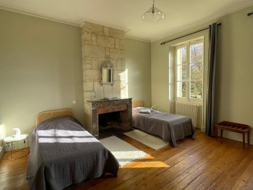 1 dormitorio con 1 cama y chimenea en Château Valoux en Cadaujac