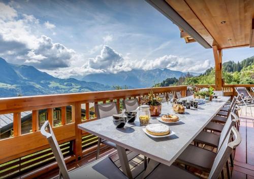 uma mesa numa varanda com vista para as montanhas em Chalet Guimauve - Les Congères em Manigod