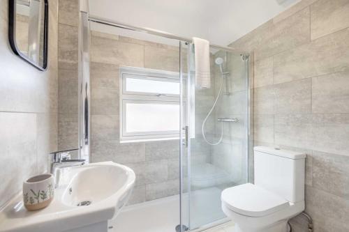 a bathroom with a shower and a toilet and a sink at 4BR Home Close to Slough Station, Private Driveway in Canvey