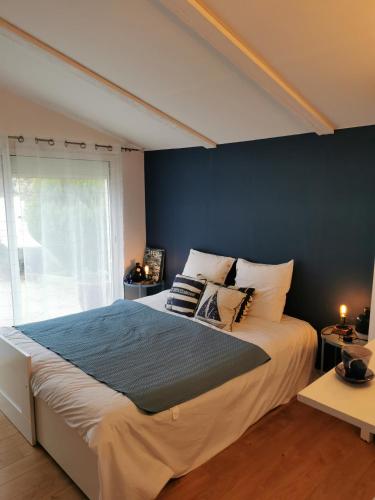Le Refuge de Manou في سان-بيراي: غرفة نوم بسرير كبير بجدار ازرق