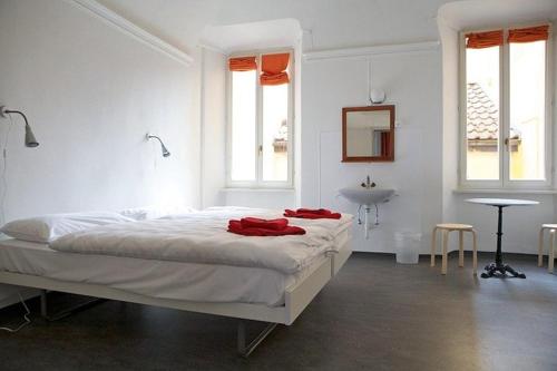 a white bedroom with a large bed and a sink at Casa Da Vinci B&B in Locarno