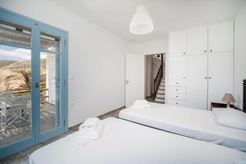 una camera con due letti e una finestra di Psili Ammos a Serifos Chora