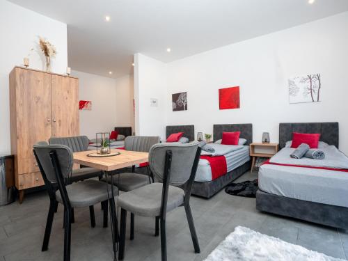 a bedroom with two beds and a table and chairs at Serviceroom24 - Apartment 3 in Recklinghausen Hoch WLAN - Smart-TV - 24-7 Check-in und Küche in Recklinghausen