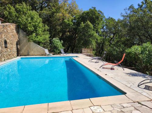 une piscine avec deux chaises et une table dans l'établissement villa suddard, à La Garde-Freinet
