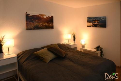 a bedroom with a bed with two lamps on it at Ferienwohnung DEU5 in Bregenz