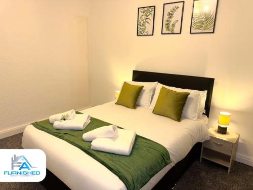 sypialnia z dużym łóżkiem z ręcznikami w obiekcie Large House - Relocation - Families w Manchesterze