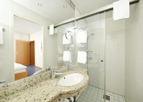 a bathroom with a sink and a shower at Bildungshaus Neckarelz in Mosbach