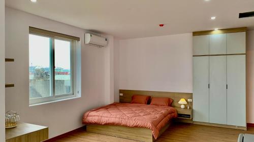 a bedroom with a red bed and a window at Bảo An Home in Thái Nguyên