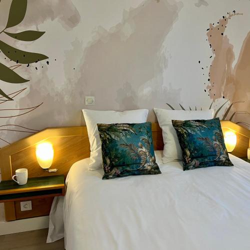 une chambre avec un lit blanc avec deux oreillers dans l'établissement Mélisande au pays des orjouliers, à Saint-Jean-de-Fos