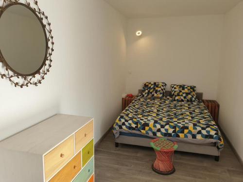 a bedroom with a bed with a mirror and a dresser at Studio de la Luciole in Mouriès