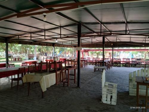 an empty restaurant with red tables and chairs at Camping Caperucita Roja in Clorinda