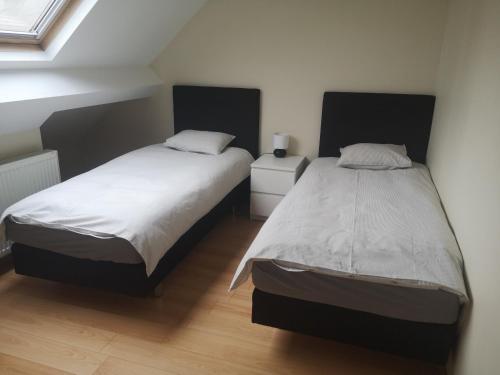 1 dormitorio con 2 camas y ventana en Basilique Corner, en Bruselas