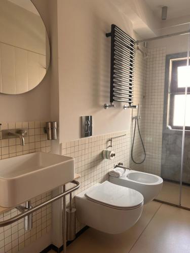 bagno con lavandino, servizi igienici e specchio di Hotel Lachea ad Acitrezza