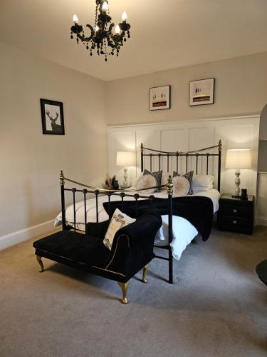 a bedroom with a large bed and a chandelier at Antfield house in Inverness