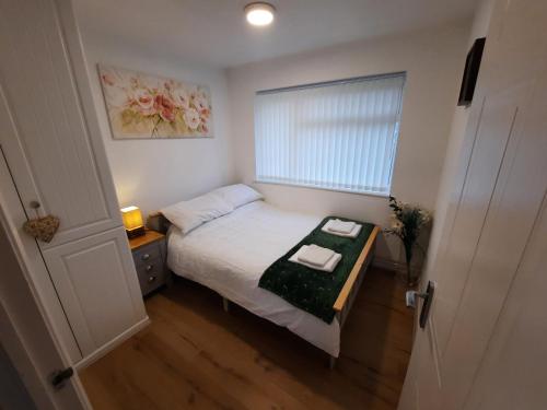 a small bedroom with a bed and a window at 2 Bed Chalet St Margaret's at Cliffe South Coast in Dover