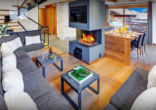 un salon avec un canapé et une cheminée dans l'établissement Chalet Macaron - Les Congères, au Grand-Bornand