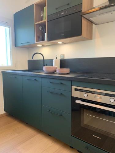 uma cozinha com armários azuis e um forno com placa de fogão em PROVENCE facile em Le Tholonet