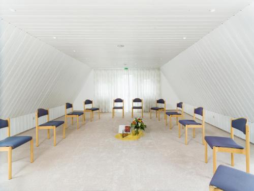 an empty room with chairs and flowers in it at Bildungshaus Neckarelz in Mosbach