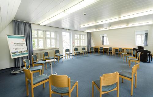 a large room with chairs and a projection screen at Bildungshaus Neckarelz in Mosbach