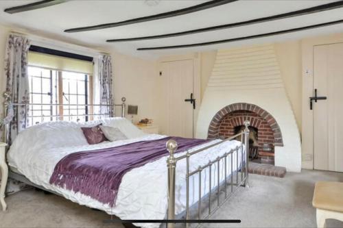 a bedroom with a large bed and a fireplace at Sea Breeze in South Hayling