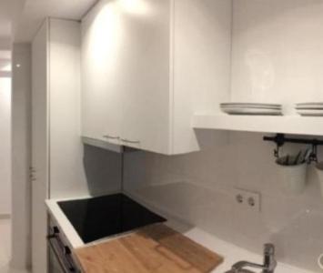 a kitchen with white cabinets and a wooden counter top at Tus Habitaciones en Ruzafa in Valencia
