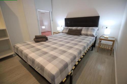 a bedroom with a large bed with a checkered bedspread at Tus Habitaciones en Ruzafa in Valencia