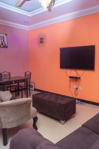 a living room with a flat screen tv on a wall at Legacy Apartment Phase 1 in Brufut