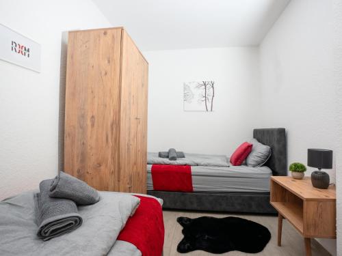 sypialnia z dwoma łóżkami i pies leżący na podłodze w obiekcie SR24 - Stillvolles gemütliches Apartment 4 in Recklinghausen w mieście Herten