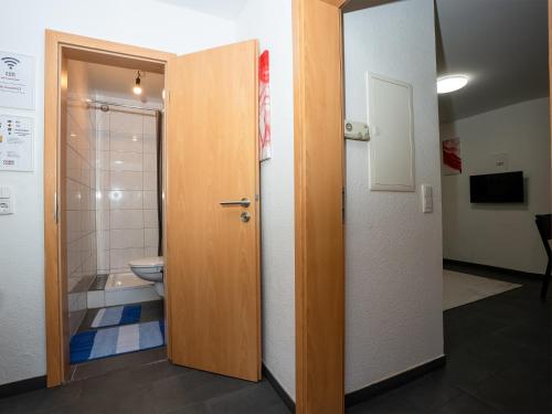 une porte ouverte menant à une salle de bains pourvue de toilettes. dans l'établissement SR24 - Stillvolles gemütliches Apartment 4 in Recklinghausen, à Herten