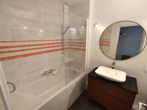 une salle de bain avec un lavabo, une douche et un miroir dans l'établissement Appartement pour 4/5 personnes, les pieds dans l'eau, à La Baule