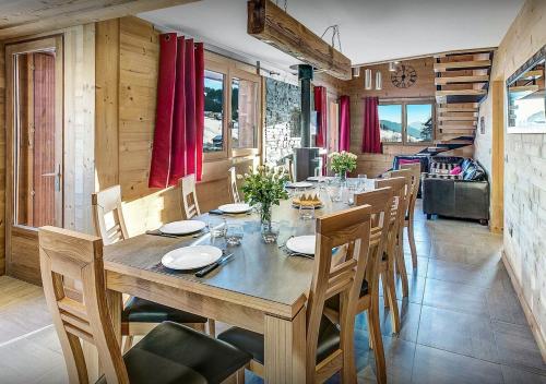uma sala de jantar com uma mesa de madeira e cadeiras em Chalet Sicoria - Les Congères em Le Grand-Bornand