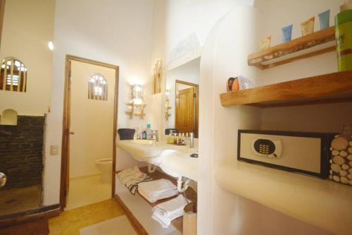 a bathroom with a sink and a toilet and a mirror at Havre de paix, 2 pas de la plage in Las Terrenas